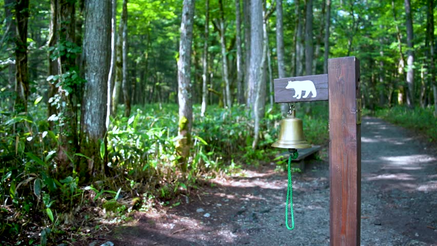 A big bear bell to let bears know people are here in Kamikochi National Park in the Northern Japan Alps of Nagano Prefecture, Japan. Beautiful mountain in autumn leaf and Azusa river