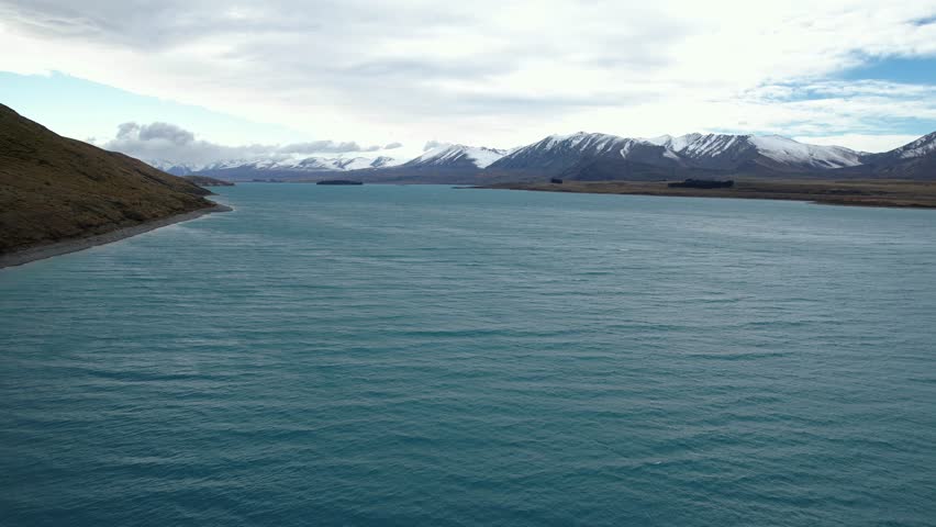Aerial View Of Lake Tekapo With Snowy Mountain Range In The Background In South Island, New Zealand.