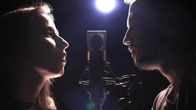 Man and woman singing into a microphone face to face - Powered by Shutterstock - Get 15% off with code: PIKWIZARD15