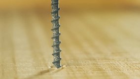 Close-up screwdriver bit screwing black countersunk self-tapping screw into wooden plank. Hardware tool tightening coarse fastener during repair. Bit working in construction moment - Powered by Shutterstock - Get 15% off with code: PIKWIZARD15