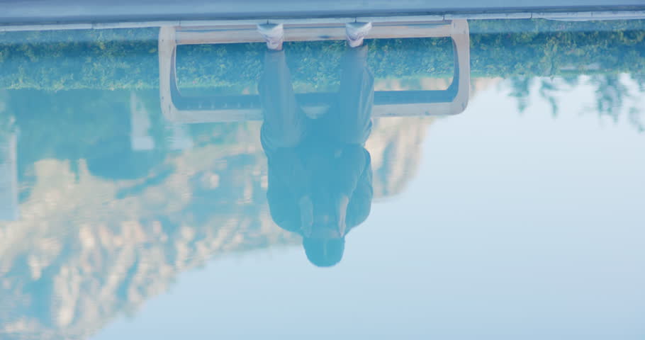 Inverted shot flipping revealing Asian woman sitting pool bench rubbing shoulder gathering resolve. Reflection, tranquility, mindfulness, serenity, contemplative, relaxation, elegance