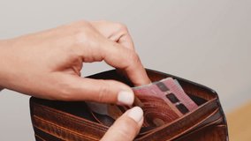 Unrecognizable woman counting euros in her wallet or purse. Counting twenty-dollar bills close-up. - Powered by Shutterstock - Get 15% off with code: PIKWIZARD15
