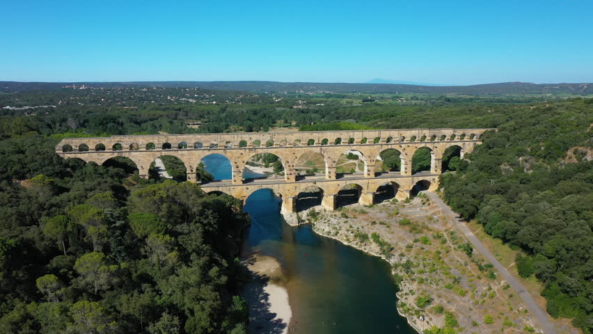 The Pont du Gard is an ancient Roman aqueduct, that is depicted  on five euro note. Summertime.