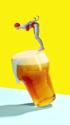 Short product video. Swimmer standing on edge of glass of beer ready to dive to pool of fun and rest. Concept of summer, holidays, celebration, Friday mood, festivals.