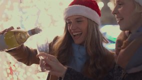 Slow motion close-up of sparkling wine being poured into a champagne flute as happy young women celebrate Christmas and New Year's Eve together. - Powered by Shutterstock - Get 15% off with code: PIKWIZARD15