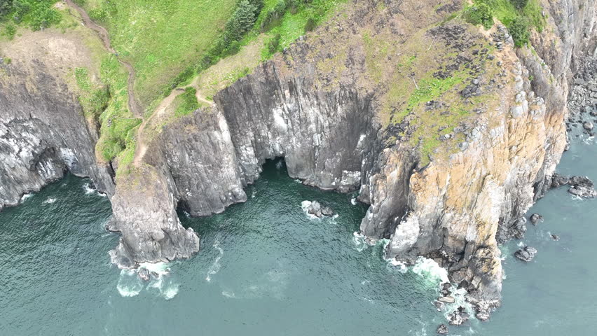 The Pacific Ocean washes against the rugged, rocky shoreline of northern Oregon, just south of Cannon Beach. This part of the Pacific Northwest has incredibly scenic coastlines and beaches.