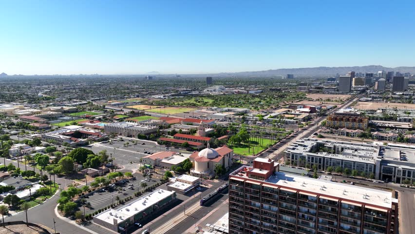 Aerial view of the Downtown Phoenix skyline featuring a mix of modern skyscrapers and older buildings, a vibrant scene under a clear blue sky, Phoenix, Arizona, United States.