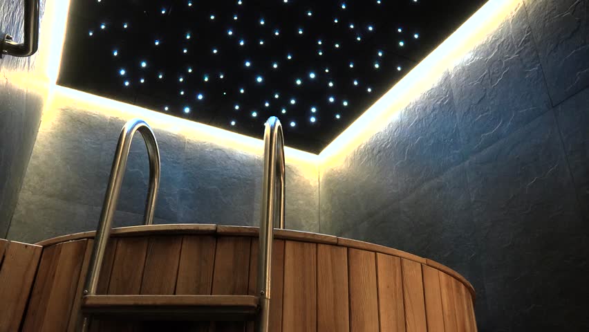 an indoor little wooden round pool with silver stairs