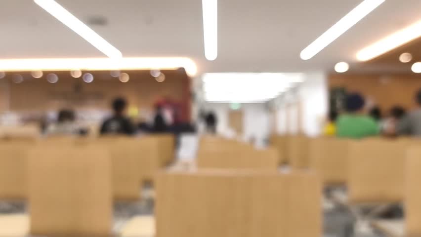 Blurred chairs and people' activities in office building