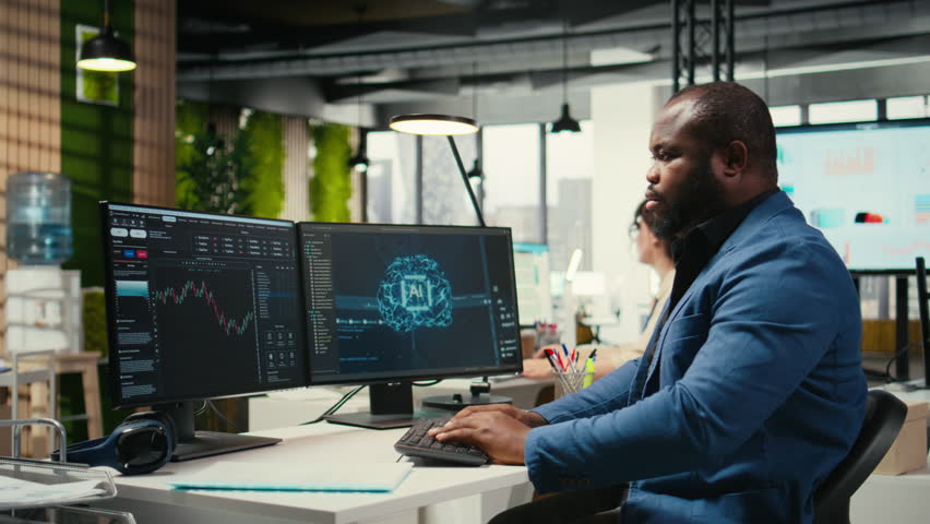 African american technician studies AI financial forecast development with neural networks systems on pc, deep learning data processing. Adaptive algorithms for decision making. Camera A.