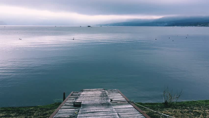 Wooden boardwalk, serene lake shore, peaceful morning, nature walkway, lakeside stroll