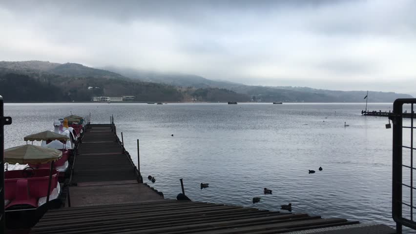 Wooden boardwalk, serene lake shore, peaceful morning, nature walkway, lakeside stroll