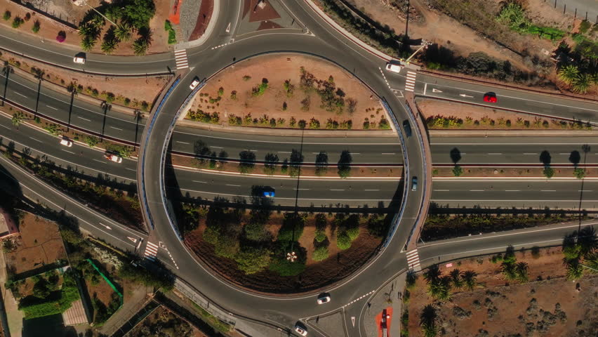 Aerial: roundabout with cars and traffic during the day in Gran Canaria, Spain, spiral top down drone shot
