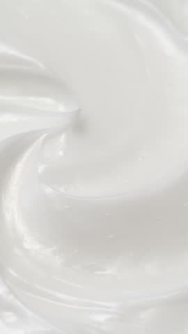 Vertical closeup white eye, skin cream texture background, facial cosmetics mask