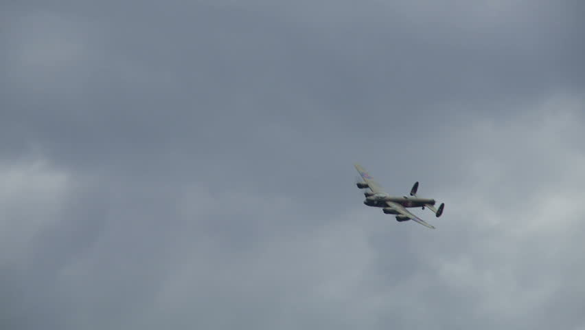 Avro Lancaster bomber plane from World War II flies past followed by a Spitfire