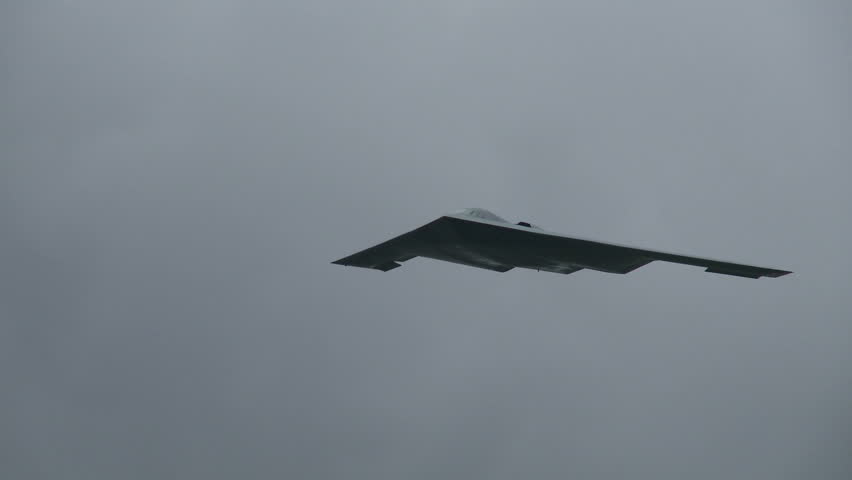 Northrop B-2A Spirit stealth bomber flying in a cloudy sky.