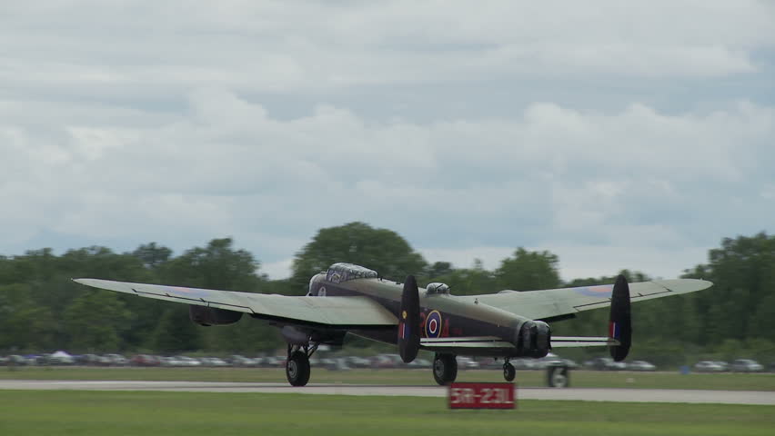 Avro Lancaster bomber plane from World War II taking off from an airfield.