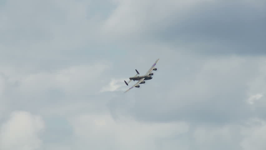 Avro Lancaster bomber plane from World War II flies around towards camera in a