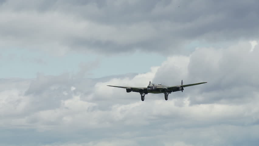 Avro Lancaster bomber plane from World War II landing at airfield.