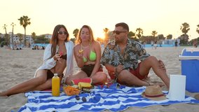 Friends are sharing snacks and enjoying each other's company during a vibrant sunset picnic on the beach - Powered by Shutterstock - Get 15% off with code: PIKWIZARD15