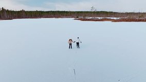 Romantic couple skating hand in hand across Cenu bog lake in slow motion Latvia - Powered by Shutterstock - Get 15% off with code: PIKWIZARD15