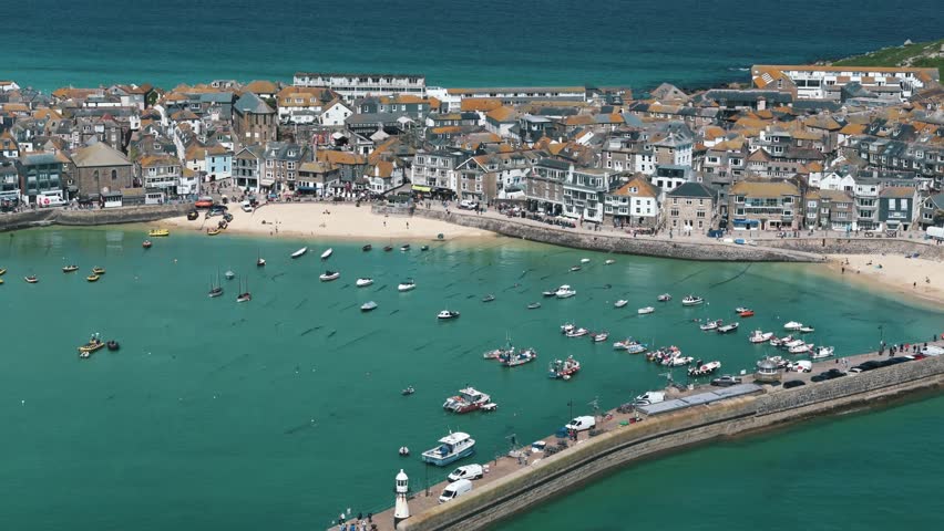 Descending drone pan up over vivid St Ives bay with deep blue ocean beyond