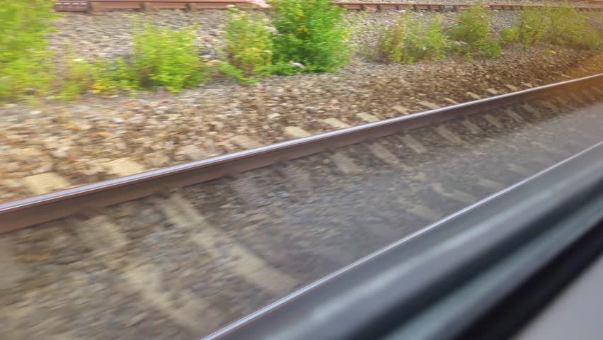 Fast Moving View of Railway Tracks as Train Moves at Speed. Public Transportation Footage on British Rail Network. Wooden Sleepers Supporting Hot Rolled Steel for Carriage to Ride On.