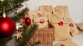 christmas eco-friendly advent calendar idea. woman places craft bag with gift near fur tree - Powered by Shutterstock - Get 15% off with code: PIKWIZARD15