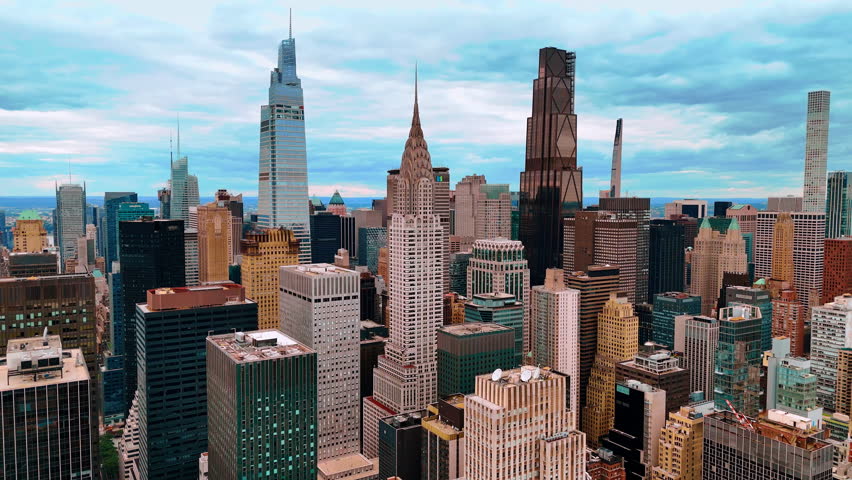 Chrysler Building in the scenery of New York midtown. Drone footage approaching the famous skyscraper on a cloudy daytime.