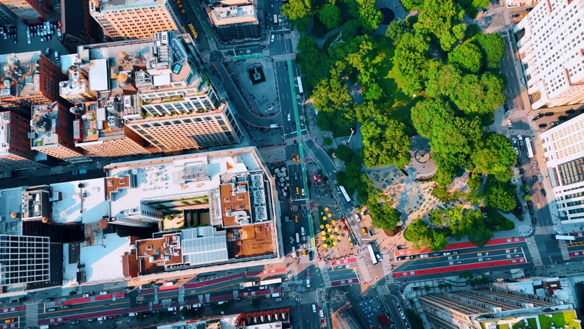 Footage above the greenery of Madison Park in New York, USA. Transport moves by the streets of Manhattan.