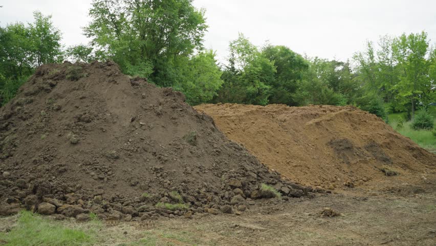 Two dirt piles for backfill and landscaping at pool build site in Wisconsin.