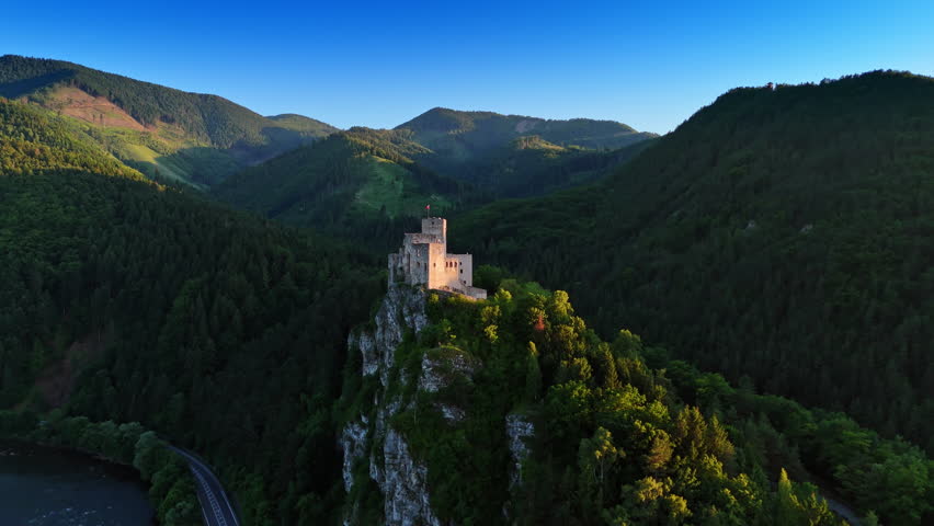 Beautiful castle located on the mountain top over the river. Mighty verdant mountains at backdrop. Strecno Castle, northern Slovakia. Aerial view.