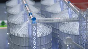 Detailed model of an industrial grain silo complex with metal storage bins, top conveyors, and support structures. Educational or presentation display showing logistics of agricultural grain handling. - Powered by Shutterstock - Get 15% off with code: PIKWIZARD15