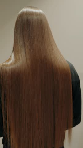 Combing a client's hair in a salon. Hair care, Combing Long, Silky Smooth Brown Hair in Salon. Hair Care and Beauty