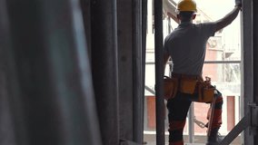 A construction worker monitors work progress from a scaffold on a busy urban construction site in bright daylight, ensuring safety and coordination. - Powered by Shutterstock - Get 15% off with code: PIKWIZARD15