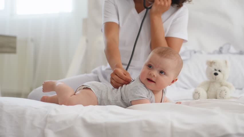 Using stethoscope. Close up of nurse that is checking newborn baby.