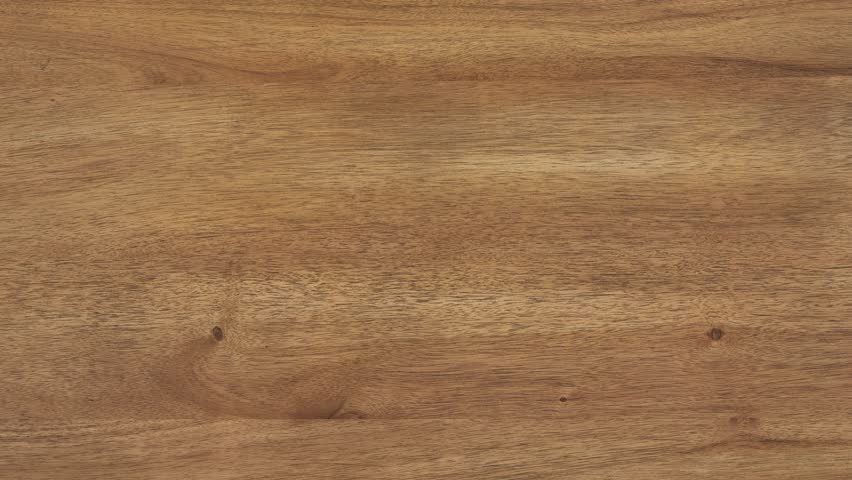 Camera zooms slowly, revealing fine wood grain across tabletop
