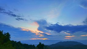 Time lapse sunrise above a dense forest, casting a golden glow through billowing clouds and mist. This captivating scene blends warm and cool tones, creating a dramatic and serene natural landscape. - Powered by Shutterstock - Get 15% off with code: PIKWIZARD15