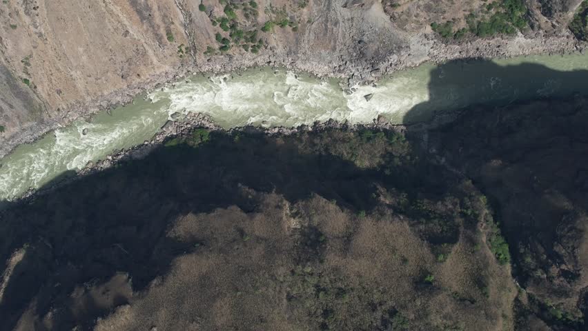 A dramatic aerial shot of Tiger Leaping Gorge showing turbulent river waters and steep canyon walls