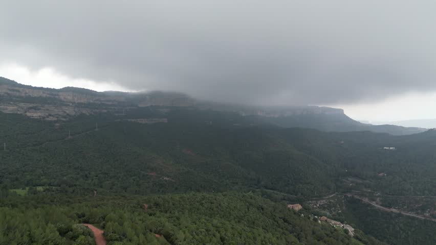 Aerial view of forested hills under cloud cover, Spain.