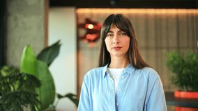 Passionate businesswoman, wearing a blue shirt, powerfully speaks into a megaphone indoors. Her serious expression conveys an important, urgent announcement. - Powered by Shutterstock - Get 15% off with code: PIKWIZARD15
