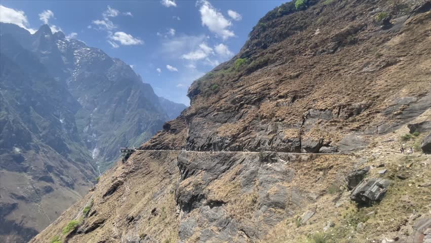A drone shot capturing the winding path of the Jinsha River cutting through the cliffs of Tiger Leaping Gorge in Yunnan, China