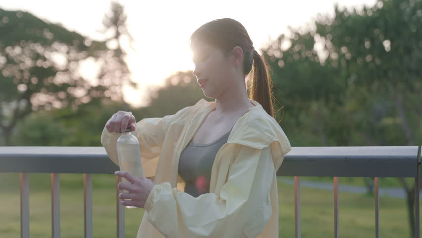 Asian women are healthy, waking up early to exercise in the park. Their favorite sports are running and yoga. They stop to drink water to refresh themselves.