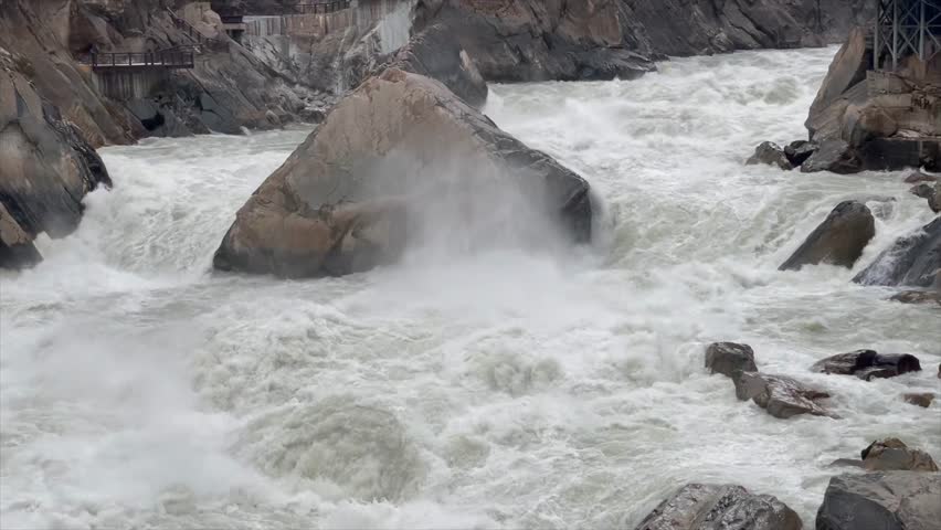 Powerful Water flowing powerfully through Tiger Leaping Gorge in Yunnan, China, Jinsha River carving through steep canyon walls beneath mountains