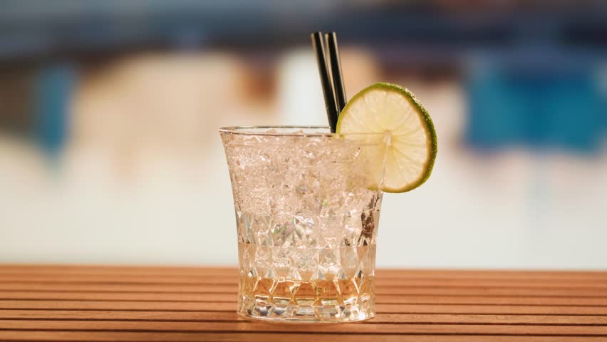 Fruit cocktail in hotel bar, Two cocktail glasses cheers in the hands on sea background. Bartenter making drink in bar, Summer vacation concept, A beautiful couple enjoy the vacation at the beach.