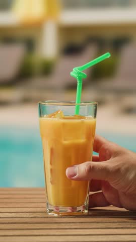 Fruit cocktail in hotel bar, Two cocktail glasses cheers in the hands on sea background. Bartenter making drink in bar, Summer vacation concept, A beautiful couple enjoy the vacation at the beach.