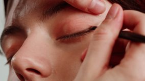 Eye shadow makeup to the upper eyeliner, close-up. Makeup artist applies a bright eye shadow with a makeup brush.Tutorial master class of professional makeup.  - Powered by Shutterstock - Get 15% off with code: PIKWIZARD15