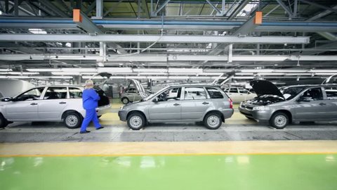 TOGLIATTI - SEP 30: Woman checks Lada Kalina cars which slide on conveyer at factory VAZ on September 30, 2011 in Togliatti, Russia. AvtoVaz factory employs more than 74 thousand people at 2012
