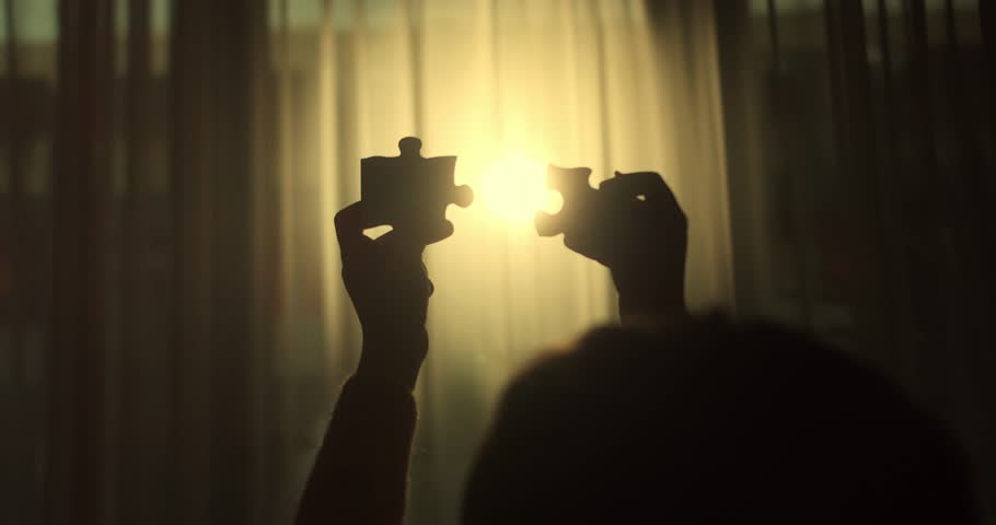 Woman s hands fit puzzle pieces together under sunlight. A metaphor for connection, collaboration, and building something greater. One part completing the whole.