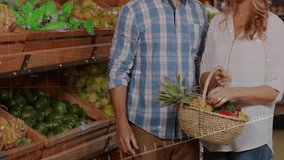 Couple shopping grocery store, woman pointing pineapple activating overlays man inspecting firmness. Fresh produce, grocery shopping, couple, healthy living, natural foods, organic, retail - Powered by Shutterstock - Get 15% off with code: PIKWIZARD15